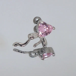 Macro di orecchino a fiocco in argento con zircone a cuore rosa su una superficie riflettente