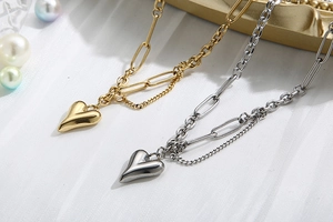 Dettagli dei pendenti a cuore oro e argento su catena a graffetta con perle