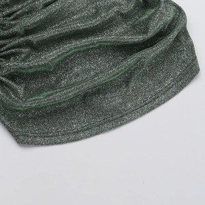 Macro detail of dark green metallic shimmer knit fabric with elegant draped texture
