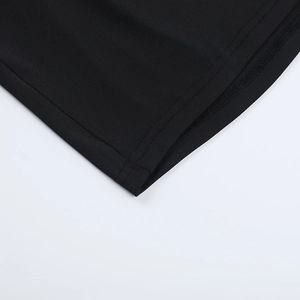 Detailed close-up showing the double-needle hem stitching on a black knit mini dress