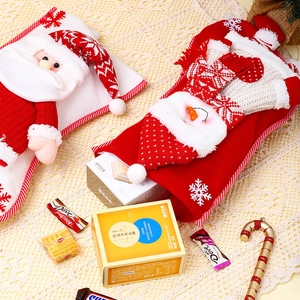 Detail of knitted Christmas stockings with 3D Santa and Snowman figures for holiday gifts