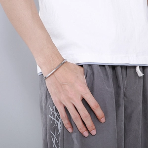 Bracelet jonc argenté torsadé porté par un mannequin pour un style moderne épuré