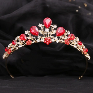 Detail of golden bridal crown with sparkling red rhinestones and crystal leaf accents