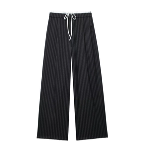 Detail der schwarzen Nadelstreifen-Weitbeinhose mit Kordelzug und weißem Innenfutter