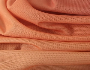 Vista dettagliata della trama del tessuto a rete arancione e delle pieghe in maglia