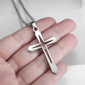 Detailed view of hollow cross pendant with polished stainless steel box chain necklace