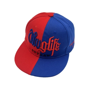 Détail de la casquette bicolore rouge et bleue avec broderie Thuglife et OUTLAW