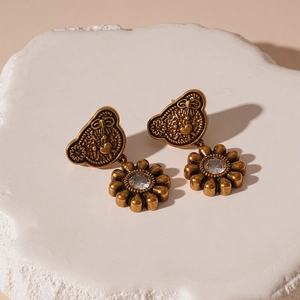 Detail of vintage gold bear and flower earrings with a large sparkling zircon crystal