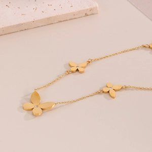 Close-up of gold butterfly bracelet with crystal inlay on a textured background