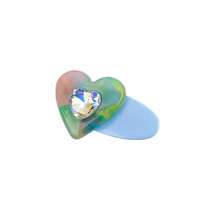 Candy colored gradient heart hair clip with iridescent gemstone on white background