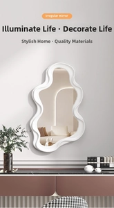 Detail view of the irregular cloud-shaped white makeup mirror on a marble tabletop