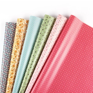 Présentation en éventail de papier cadeau style forêt avec motifs floraux et carreaux