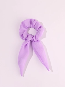 Detailed view of light purple LED hair scrunchie with long ribbons on pink background