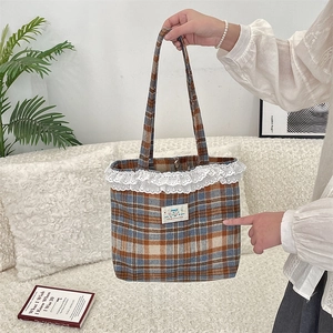 Detail of cute plaid tote bag featuring white lace trim and magnetic metal buckle closure