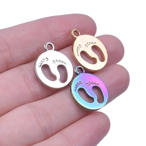 Detailed close-up of hollow footprint pendants in gold, silver, and rainbow steel finish