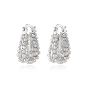 Boucles d'oreilles en argent en U avec perles sur fond blanc avec reflet miroir élégant