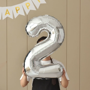 Silver 40-inch foil number 2 balloon held by a person for birthday party decoration