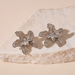 Elegant silver flower stud earrings with sparkling cubic zirconia on a minimalist stone