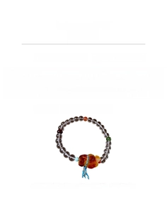 Detailed view of beaded bracelet with white crystal, jasper, and amber bear charm