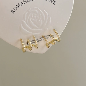 Macro shot of gold four-claw row diamond stud earrings on heart rose display card