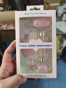 Macro view of pink quartz face roller and heart-shaped gua sha tool in gift box