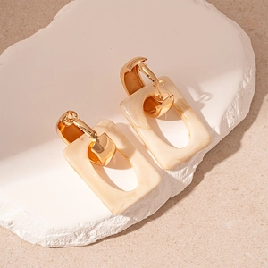 Elegant geometric resin hoop earrings with marble texture on a decorative stone base