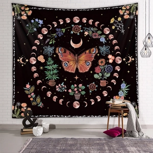 Detail showing bohemian butterfly and moon phase tapestry hanging on a white brick wall