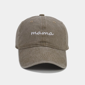 Détail macro de la broderie mama blanche sur la casquette en coton marron délavé vintage