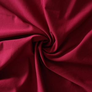 Macro shot of dark red knitted fabric texture with fine weave and elegant drape detail