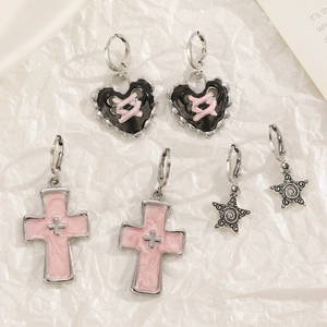 Silver hoop earrings with black heart, pink cross, and star charms in punk style