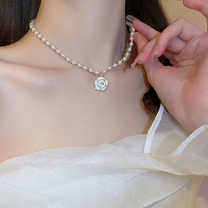 Elegant pearl choker necklace featuring a white camellia flower pendant with rhinestone center