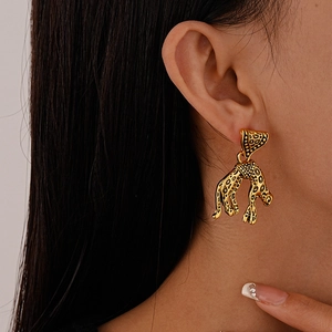 Detail view of gold leopard earrings worn by a model showcasing retro animal design
