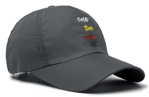 Detail of dark grey baseball cap with embroidery and laser-cut ventilation holes