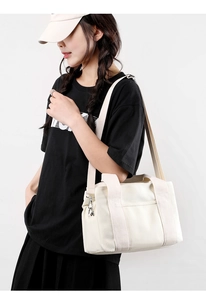 Canvas handbag with adjustable strap shown on model for size and style reference