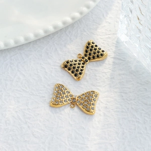 Macro shot of gold bow pendants with black and clear rhinestones for DIY jewelry