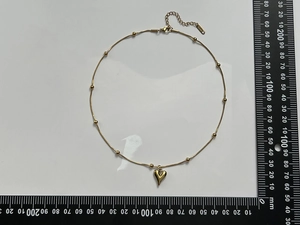 Polished gold heart pendant necklace measurement on a ruler showing the scale in mm