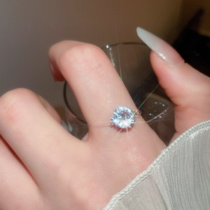 Macro shot of a floating round clear zircon stone on a transparent invisible ring band