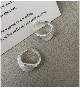 Macro view of S925 sterling silver hoop earrings with brushed texture and minimalist style