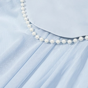 Details von hellblauem Satinkleid mit Mesh-Patchwork und elegantem Perlenausschnitt