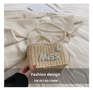 Detail of woven straw bag featuring pearl MISS lettering and elegant drawstring closure