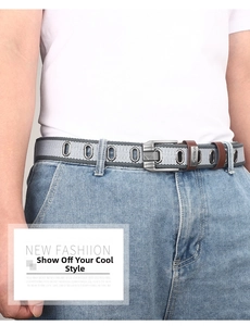 Detail of grey striped canvas belt with metal eyelets and silver buckle on denim jeans