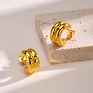 Minimalist double-layer gold C-shaped chunky earrings on a natural stone base