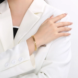 Detail view of gold tank chain bracelet on wrist featuring minimalist titanium steel links