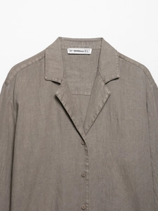 Detail of taupe linen long sleeve shirt featuring notch lapel and single-breasted buttons