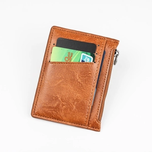 Slim brown leather card holder with zipper pocket and multiple slots on white background