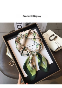 Detailed close-up of green butterfly and floral print on smooth silk scarf fabric