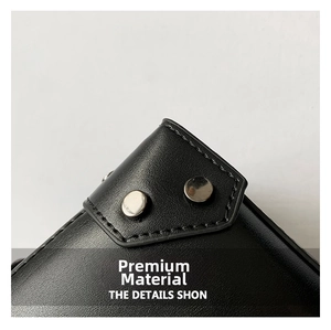 Close-up of black leather texture with precision stitching and silver metal rivets