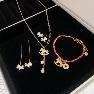 Detail view of gold horse jewelry set with necklace and earrings in a black velvet box