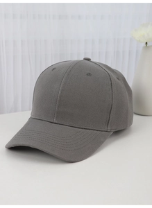 Detail shot of a grey cotton baseball cap on a clean tabletop with soft lighting