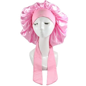Detail view of pink satin bonnet featuring long adjustable ties and elastic pleated edge